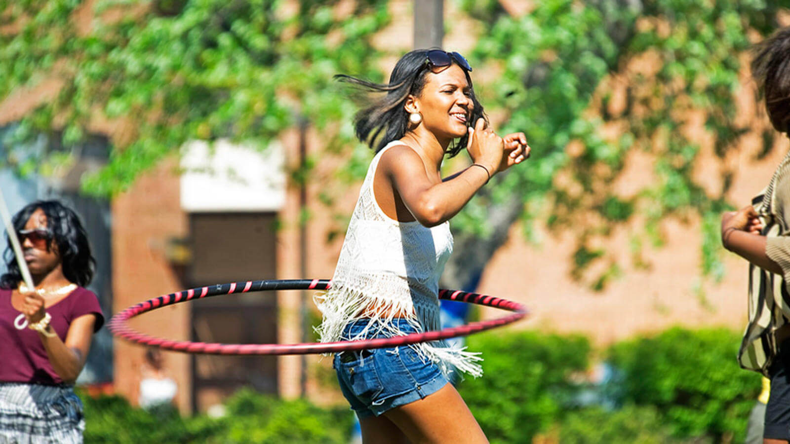 Young woman hula hooping on the Yard.