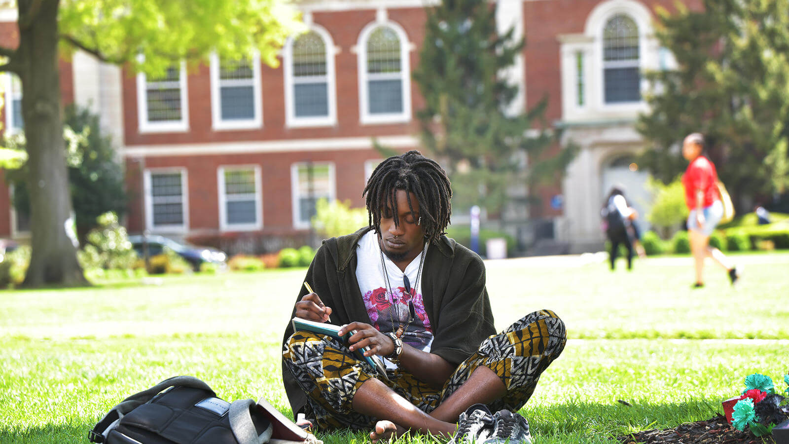 A young man writing in his notebook on The Yard.