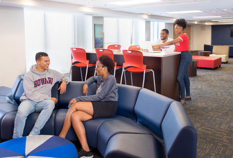 Students sitting on a curved, blue couch.