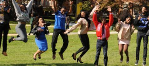 Members of Greek organizations jumping in the air.