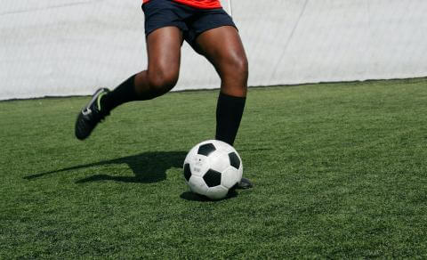 Photo of woman playing soccer, cropped at the waist.