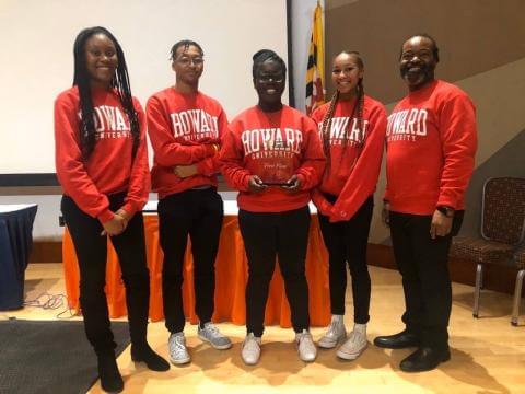 Students from the Honda Campus All-Stars Challenge team and their coach posing in red Howard sweatshirts.